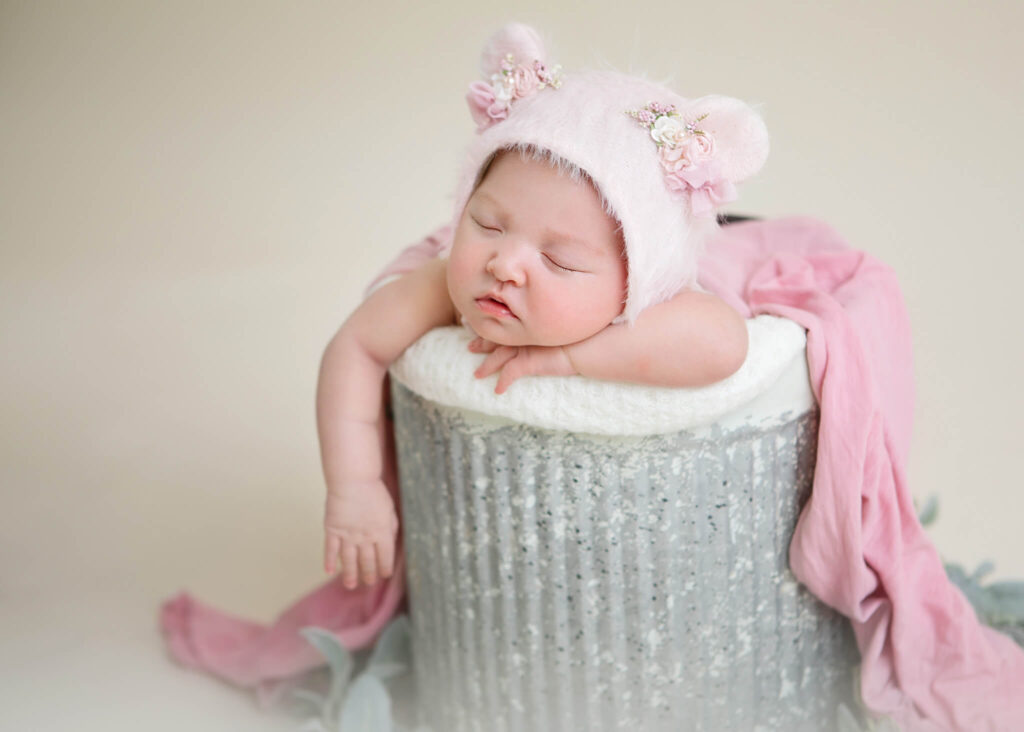 Newborn baby in a bucket with pink teddy bonnet on - Cedars Sinai Maternity Ward
