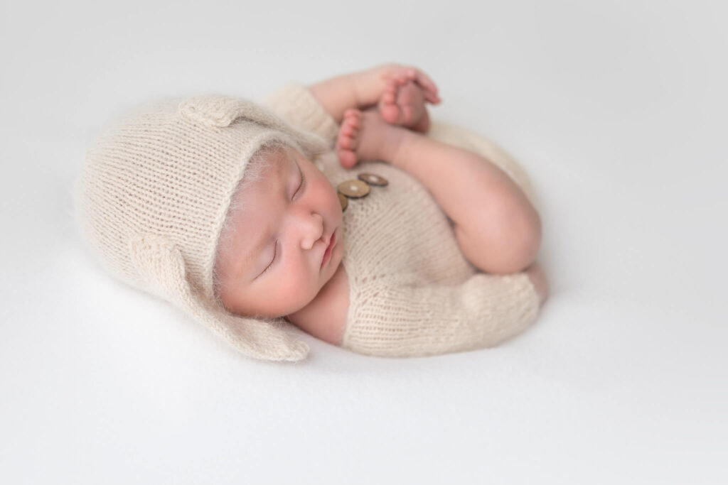 Newborn baby wearing a cute romper and bunny hat fast asleep during her newborn photoshoot in Los Angeles - 11 diaper bag essentials for moms in Los Angeles