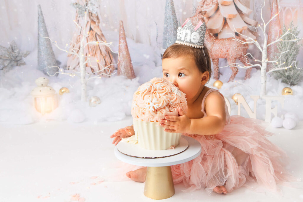 Toddler girl in pink dress eating a giant birthday cupcake in a photoshoot - Best Birthday Cakes in Los Angeles