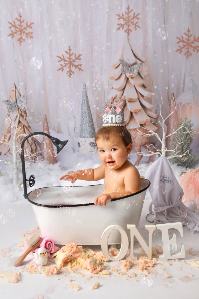 Baby girl in splash time photoshoot with Woodland Hills Photographer. Winter onederland theme with cake smashed around