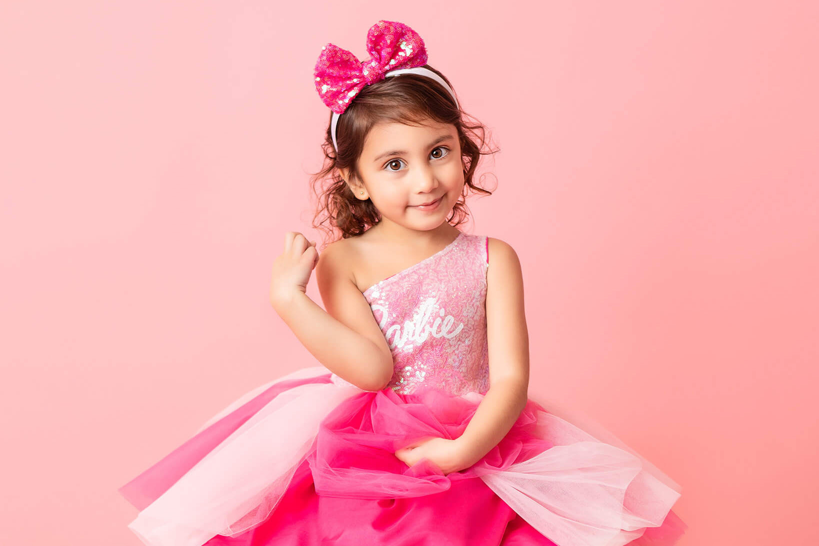 Little girl in barbie dress photographed on pink backdrop by Elsie Rose Photography - pediatric dentist los angeles