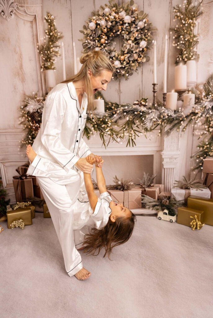 Mom playing with her daughter at Christmas in LA with a white and gold background