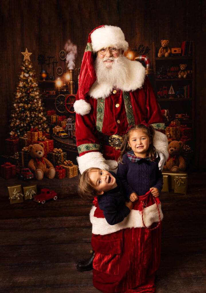 Two little children climbing into Santa's sack